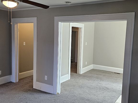 Den with master bedroom to left, hallway in middle, and dinning room and kitchen to right.