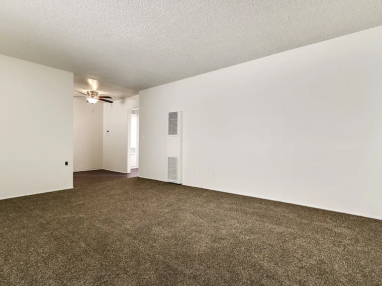 Living room with air conditioning, carpeted floors, and wood style floors in dining area