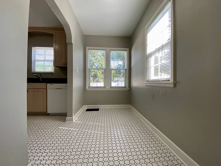 Bright and inviting kitchen area with modern hexagon tile flooring and large sunlit windows. Bright and inviting kitchen area with modern hexagon tile flooring and large sunlit windows.