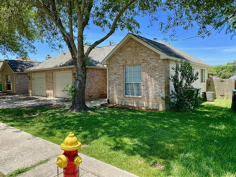 Front and side yard, gate to backyard, AC and Trash cans