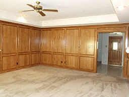 Oversized den features beautiful gas log fireplace,ceiling fan,gorgeous wood panel walls!
