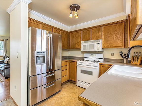 New stainless steel refrigerator and brushed nickel faucet punctuate the kitchen and its ample cupboard storage.