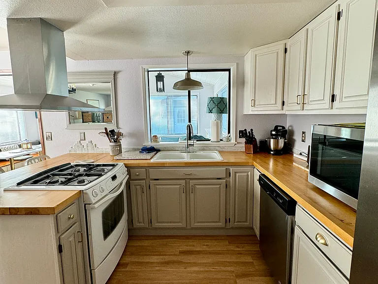 Kitchen stocked with appliances, plates, cups, cutlery etc.