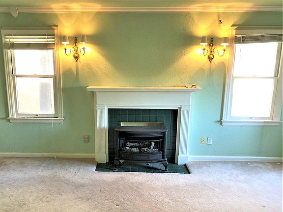 Living room fireplace. Note gas logs. They are functional and ideal for taking the chill off things.