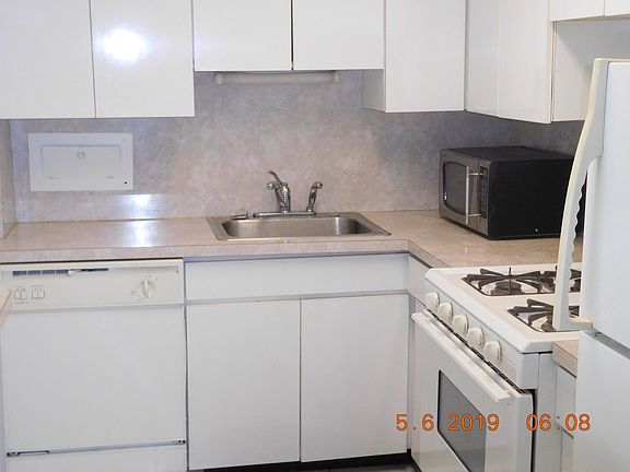 THE KITCHEN IS ALL WHITE. GAS STOVE IS PRETTY EXTRAORDINARY IN A HIGH-RISE.  WHITE GLOSS CABINETS.
