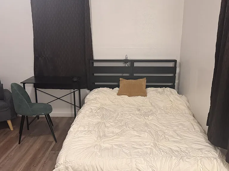 Furnished with a full bed, desk and chair setup, and wood-look flooring for easy upkeep.