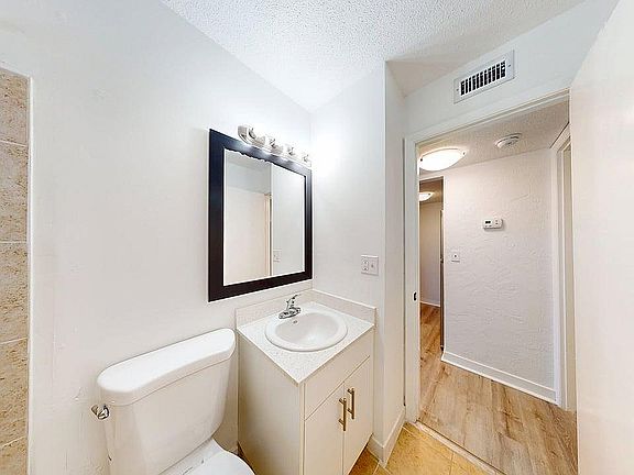 Bright, modern bathroom with elegant fixtures and a spacious layout, featuring a sleek countertop and warm lighting.