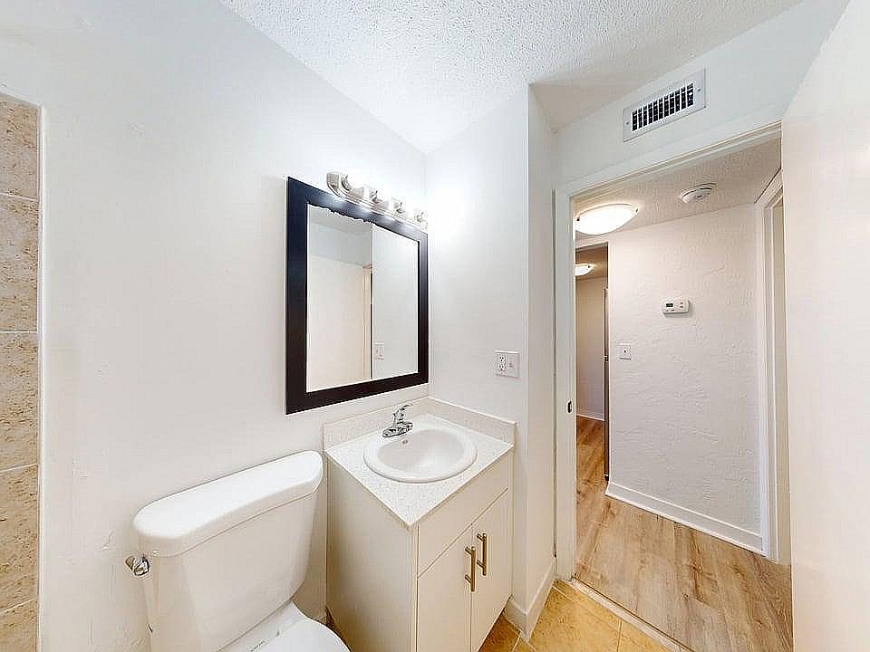 Bright, modern bathroom with elegant fixtures and a spacious layout, featuring a sleek countertop and warm lighting.