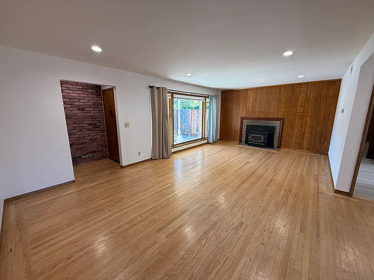 Bright, airy living room features bay window, hardwood flooring throughout and a patio door that flows to a relaxing backyard.