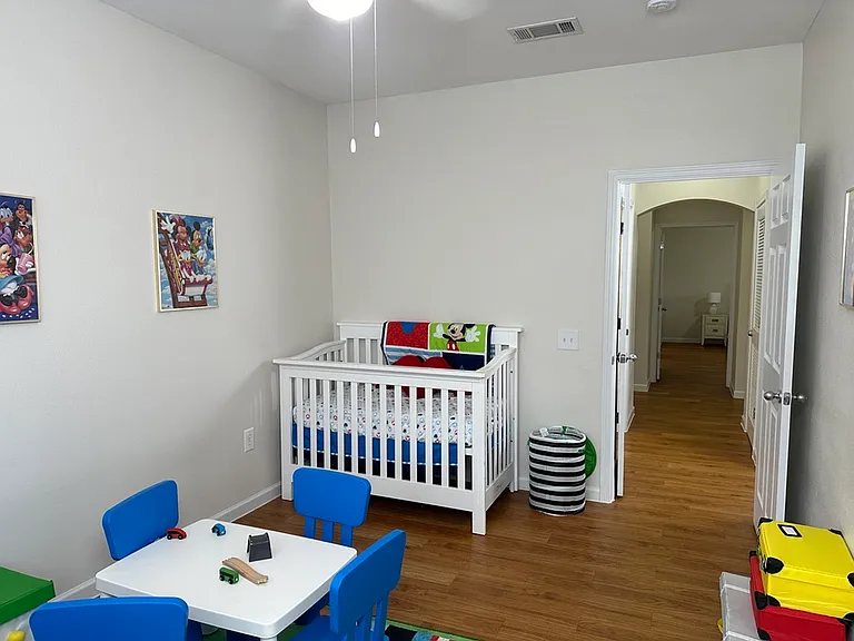 Charming children's room with colorful decor, featuring a cozy crib and playful activity table, perfect for a vibrant and welcoming family home. Charming children's room with colorful decor, featuring a cozy crib and playful activity table, perfect for a