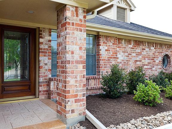 The outside of this home has a covered front porch, new sidewalk and driveway, and fresh new landsca