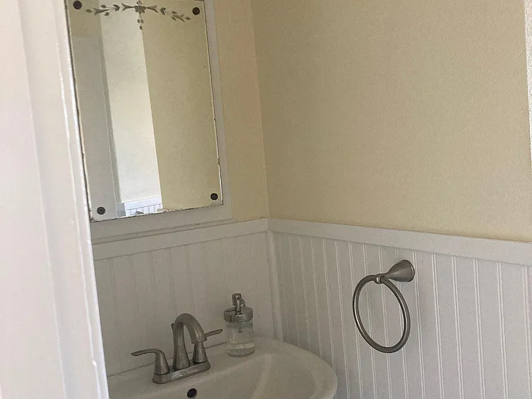 The newly remodeled bathroom features a pedestal sink and storage in the medicine cabinet.