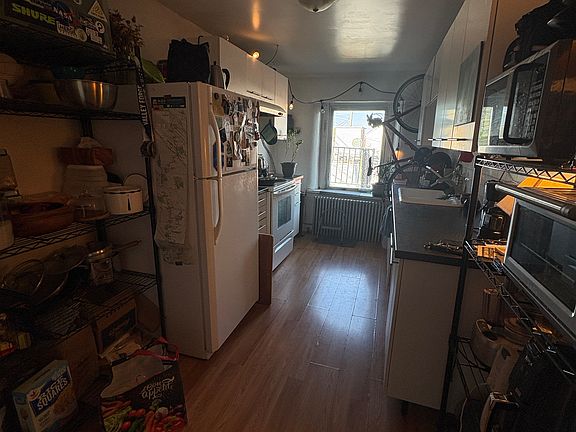 Long kitchen, with space for shelves or small kitchen table.
