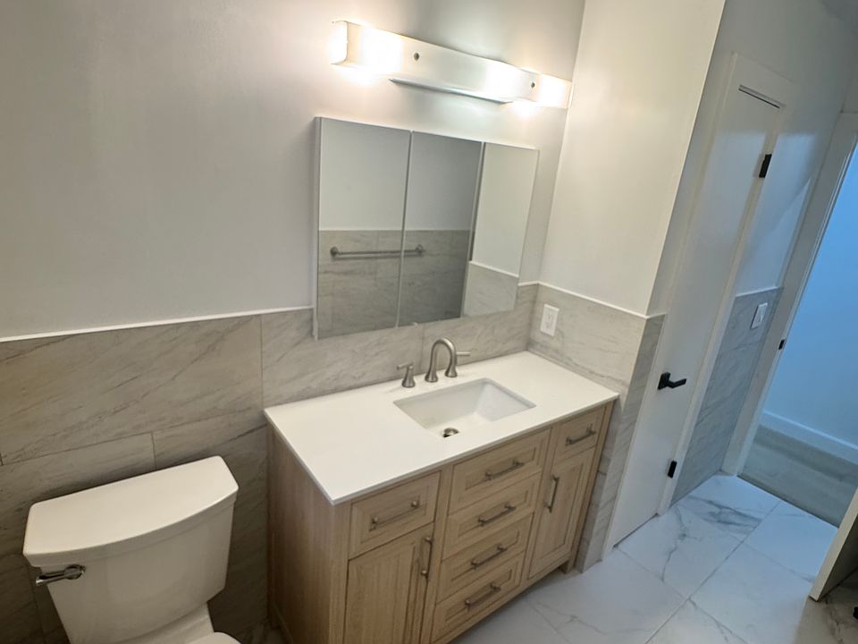 Fully renovated bathroom with large vanity with storage and linen closet