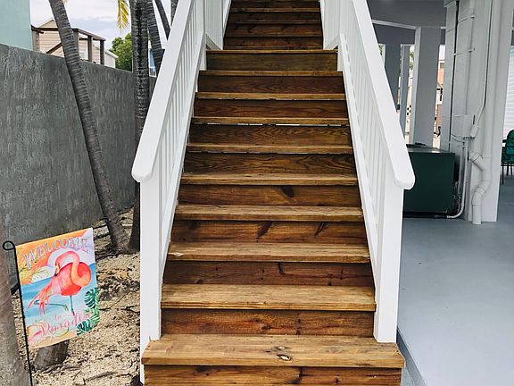 Staircase leading up to home and deck