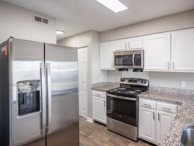 Kitchen with granite counters, modern cabinetry, and stainless steel appliances
