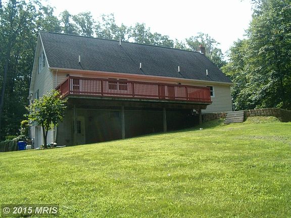 Grassy back yard with woods to rear and pet encl.
