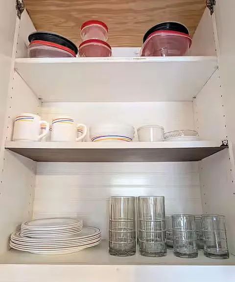 Kitchen cabinet storage stocked with dishes, mugs, and glassware for easy everyday use.