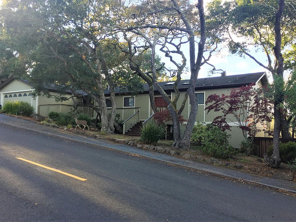Front of house with two-car garage, landscaped yard (deer resistant!), and parking.