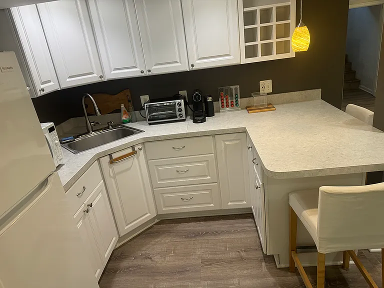 Kitchenette with Nespresso coffee maker and stools.