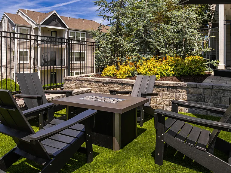 Relax and unwind in our cozy outdoor fire pit area, complete with comfortable Adirondack chairs and lush greenery. Perfect for socializing or enjoying a quiet evening under the stars.