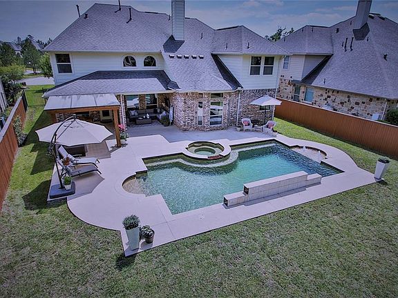 Welcome home to your own private paradise! Gorgeous custom made pool, covered patio, summer kitchen with built in grill, serving bar area, fridge and