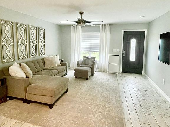 Ample living room space comes with furniture and tv shown.