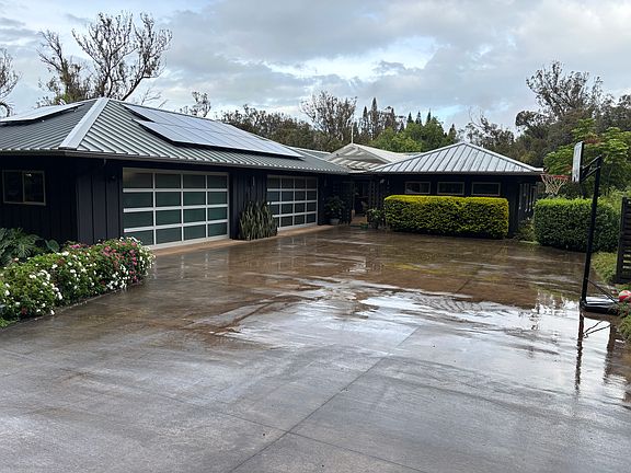 Front of house with four car garage. Owners cars are stored on one side leaving room for two cars on other side.