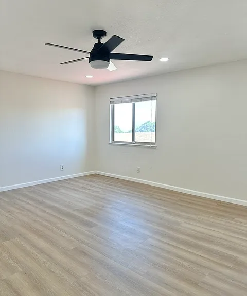 Primary room with recess lights, ceiling fan and view of the pasture