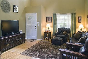 Soaring ceilings - hardwood flooring in living room.