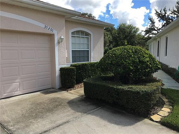 Garage, driveway & sidewalk, and manicured landscaping