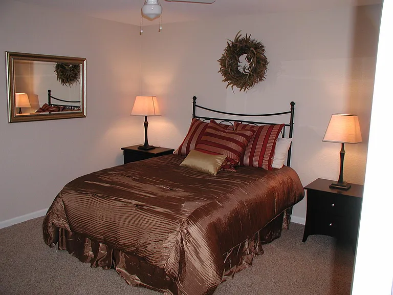 Main bedroom suite at the end of the hall includes a sliding window dressed in horizontal blinds, wall to wall carpeting, a double wide two-tie closet, lighted ceiling fan with plenty of wall sockets, and private entry to restroom with ceramic flooring.