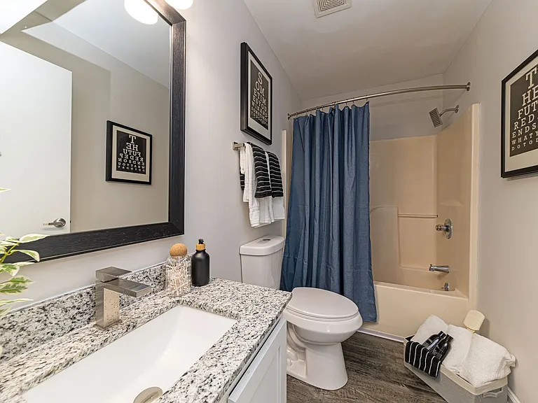 Bright bathroom with granite counters and high rise faucet