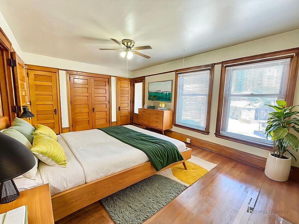Inviting bedroom with natural light, featuring wooden accents, cozy bedding, and vibrant decor.
