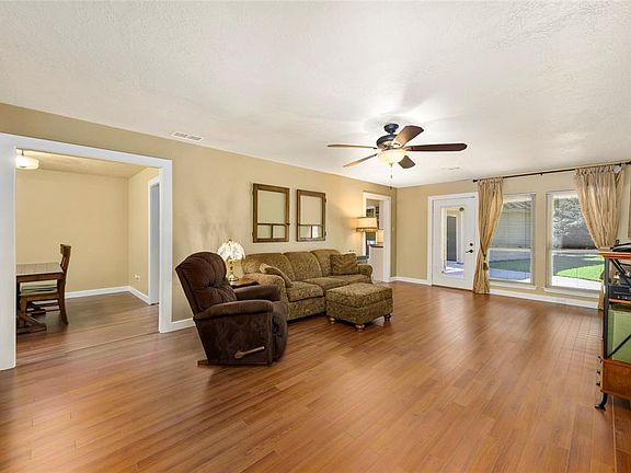 Family room view from foyer with a peak into the Formal Dining Room and lots of light from large windows into backyard