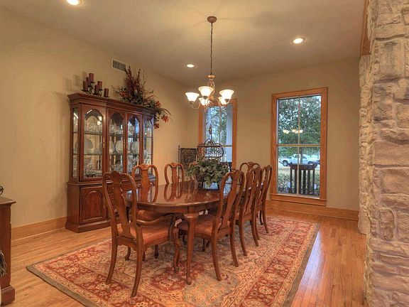 Banquet-sized formal dining room offers stately hardwood flooring, an elegant chandelier, & impressi