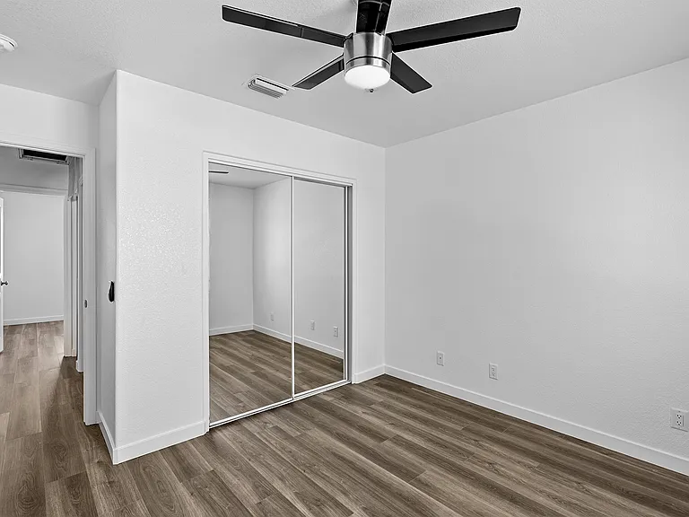 Bedroom 1; closet with mirror doors. 
Outside the door is Bathroom 1 to the right, and Bedroom 2 straight across. Living room to the left.