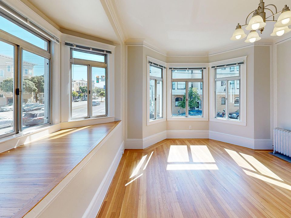 Spacious living room with a large windows and a wood-like floors