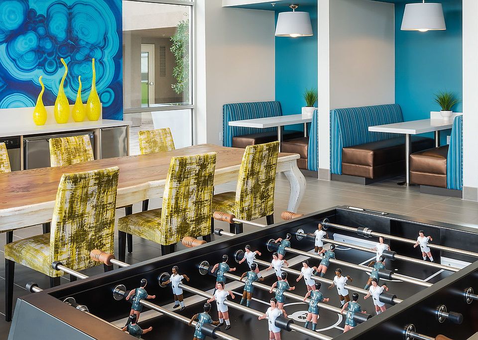 Clubhouse with dining seating, foosball table, and kitchen.