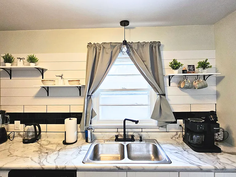 Kitchen with double sink, coffee maker, and a variety of other small appliances