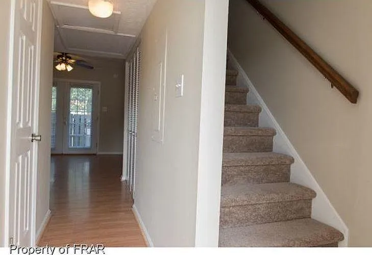 The carpeted stairwell leads to the bedrooms and a full bathroom.