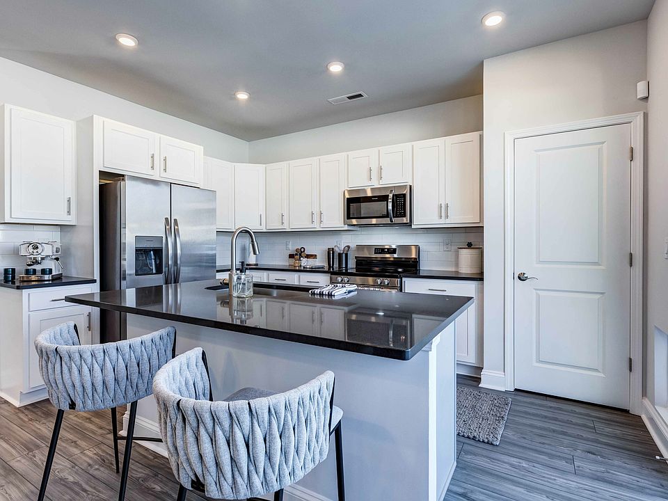 Gather and dine with Amavi Sherrills Ford's kitchens featuring a stylish kitchen island, offering room for bar seating.