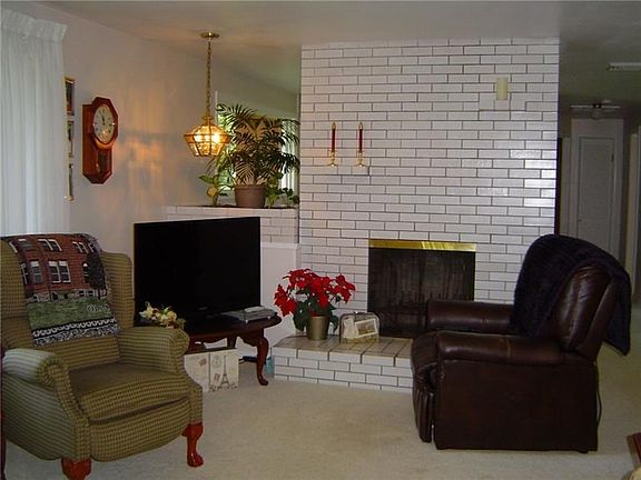 The large living room features a full length, brick fireplace.