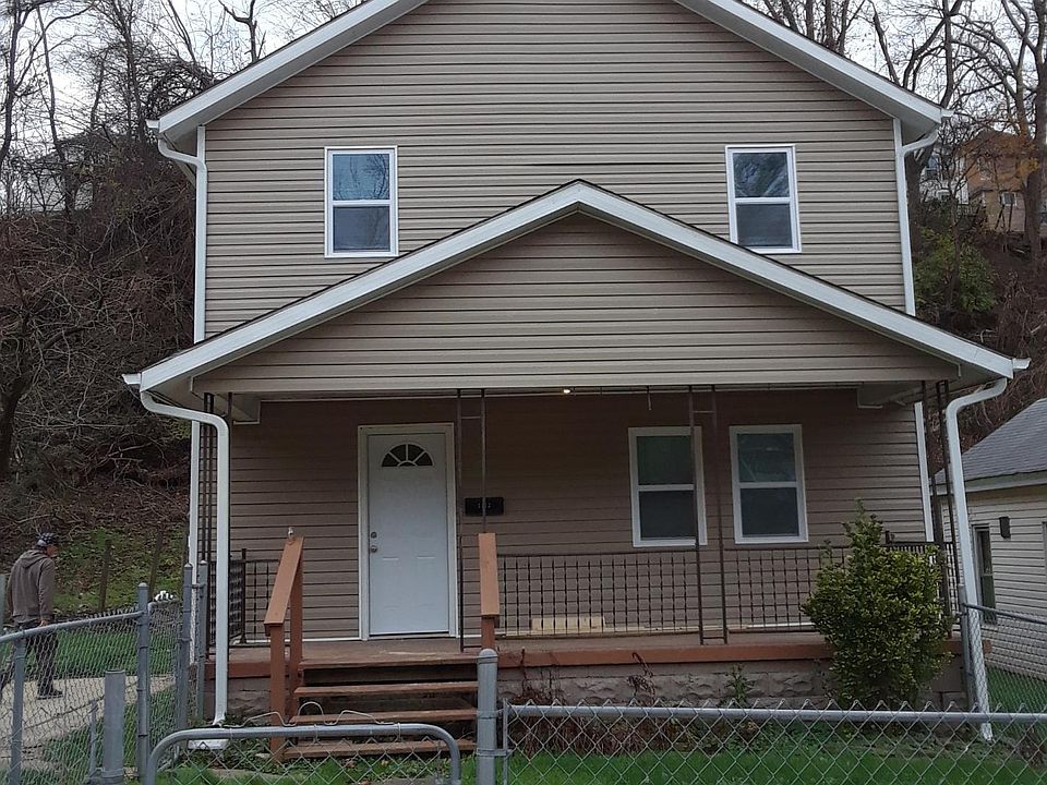 Small fenced in front yard with off-street parking to the right and left.