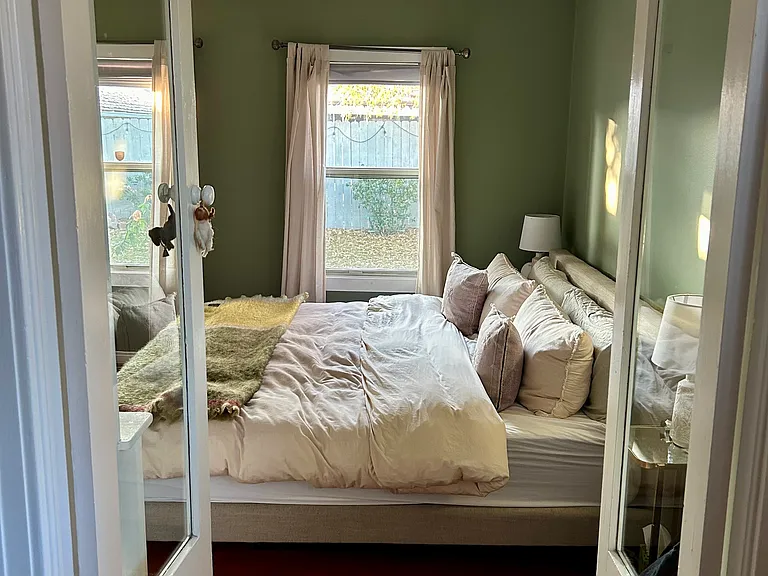 Primary bedroom on back of house; two windows that look into garden.
