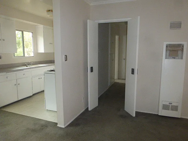door separates entry to hallway/bathroom/bedroom. Wall heater.