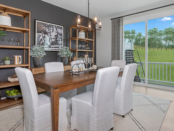 Dining area with sliding glass door to rear deck in a DRB Homes Whitaker II Model at the Legacy comm