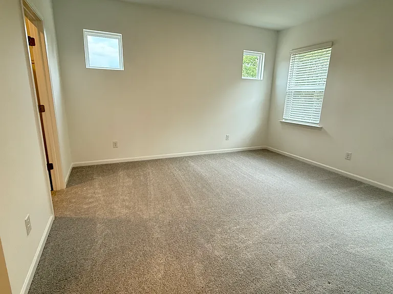 Spacious primary bedroom with abundant natural light and walk-in closet.
