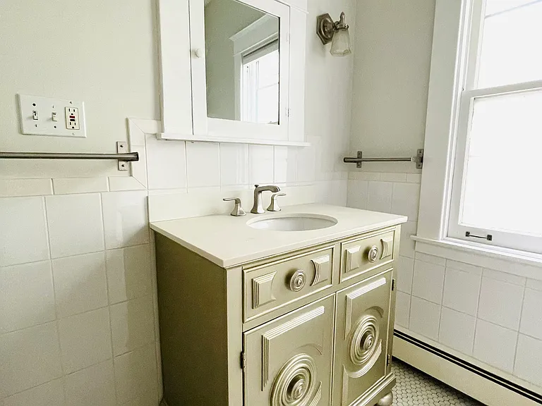 Bathroom with custom antique gold vanity sink and stone countertop and backsplash.