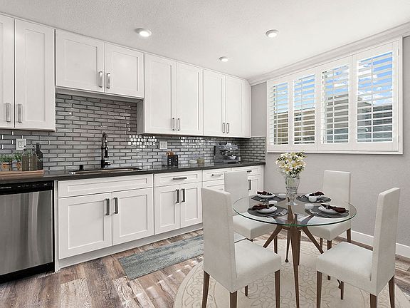 Hardwood floored dining room with view of gorgeous tiled kitchen.